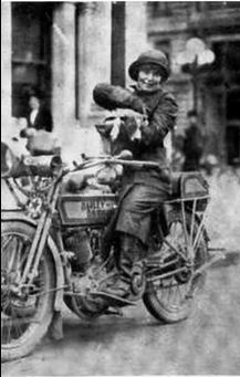 Della Crewe and her dog Trouble. There is a disk brake on the front wheel of her bike - it is actually a Corbin speedometer / odometer.