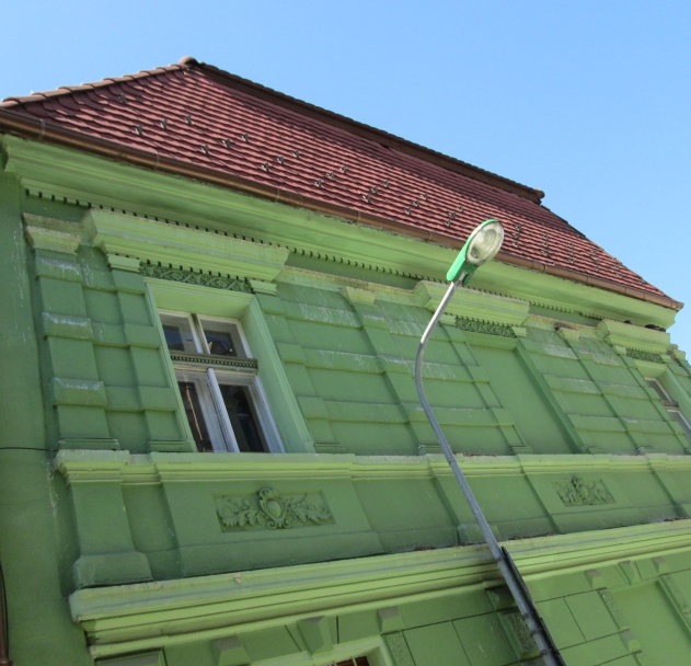 A green street light in front of a green house, Brasov, Romania. Image by @PatFurstenberg