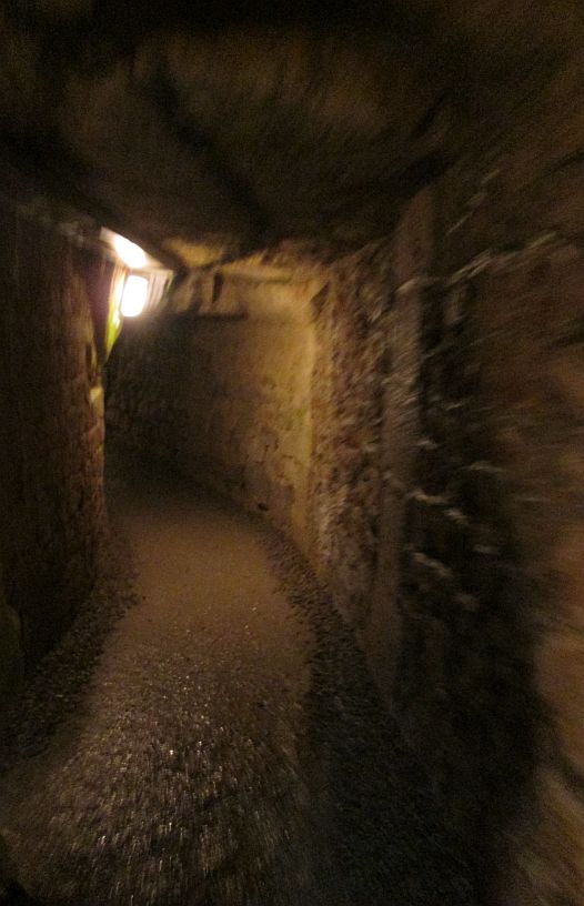 A tunnel underground, Catacombs of Paris, where life is suddenly a precious commodity.
