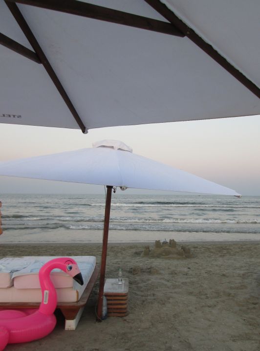 pink flamingo, sand castle, beach umbrella by the sea @PatFurstenberg
