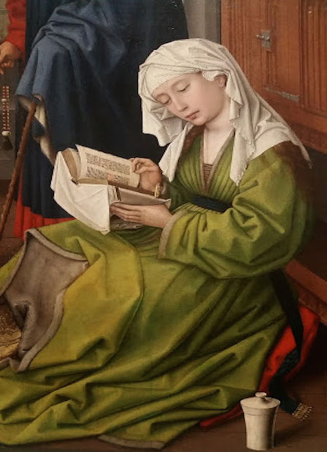 medieval woman engrossed in reading a thick book