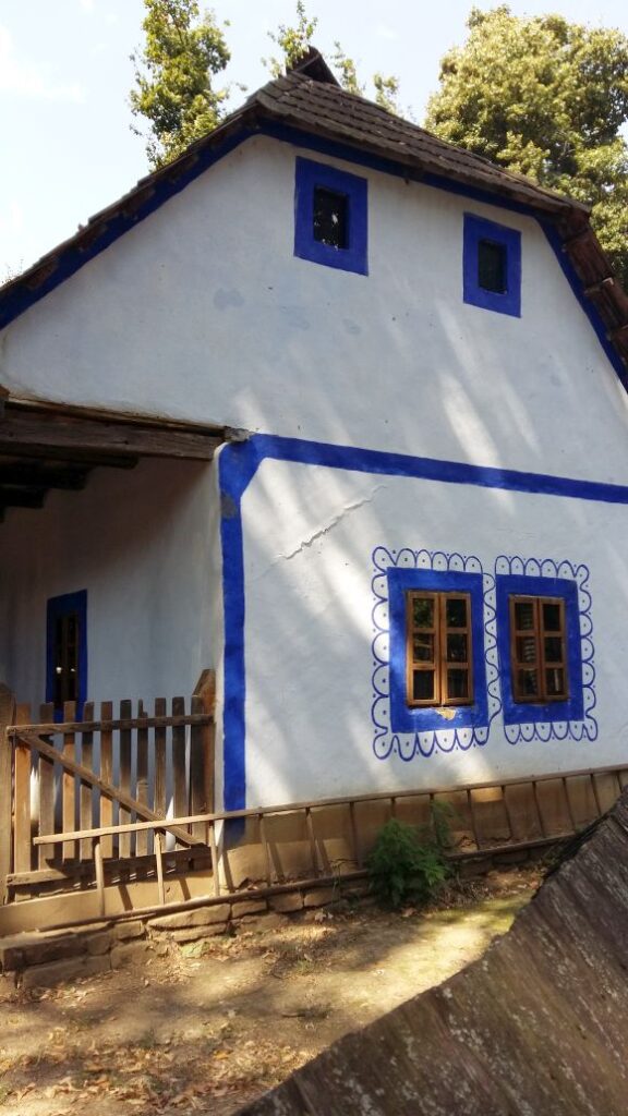 House from Dobrogea, blue windows, blue wavy line design around the windows