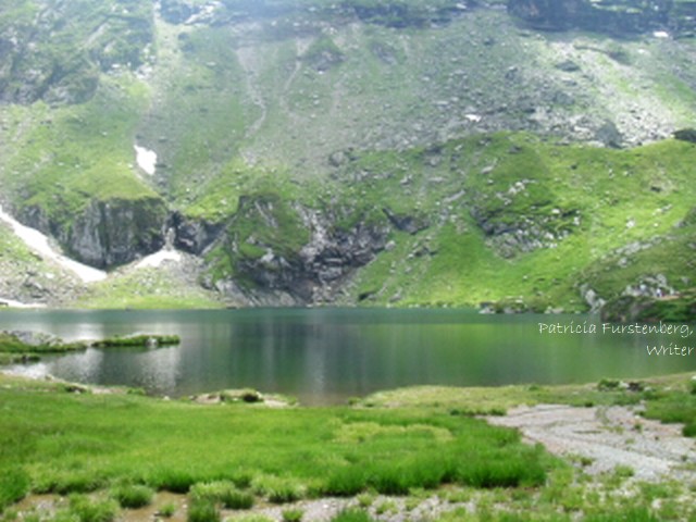 Snow and lush green grass at Bâlea Lake in July, elevation: 2 544 m