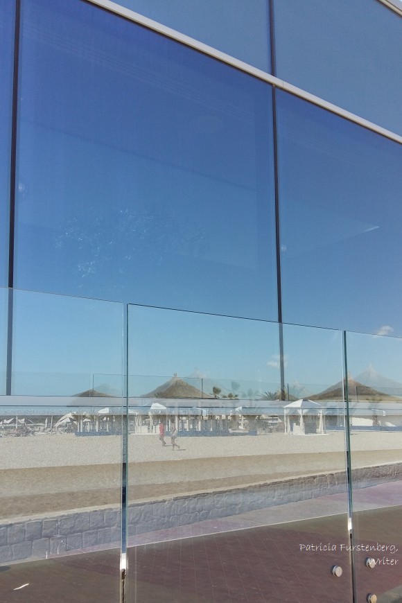 sea sand reflected in a glass building at noon